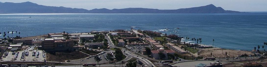 Vista panorámica del Campus Ensenada al costado del Océano Pacífico y con la península de Punta Banda a lo lejos.