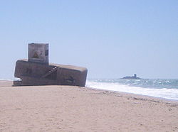 Búnker en la playa de Camposoto con castillo de Sancti Petri al fondo.