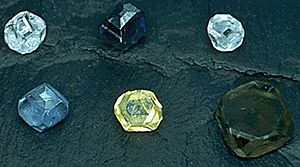 Seis cristales de diamante no faceteados, de 2-3 mm de tamaño; los colores de los diamantes son amarillo, verde-amarillo, verde-azul, azul claro, azul claro, y azul oscuro